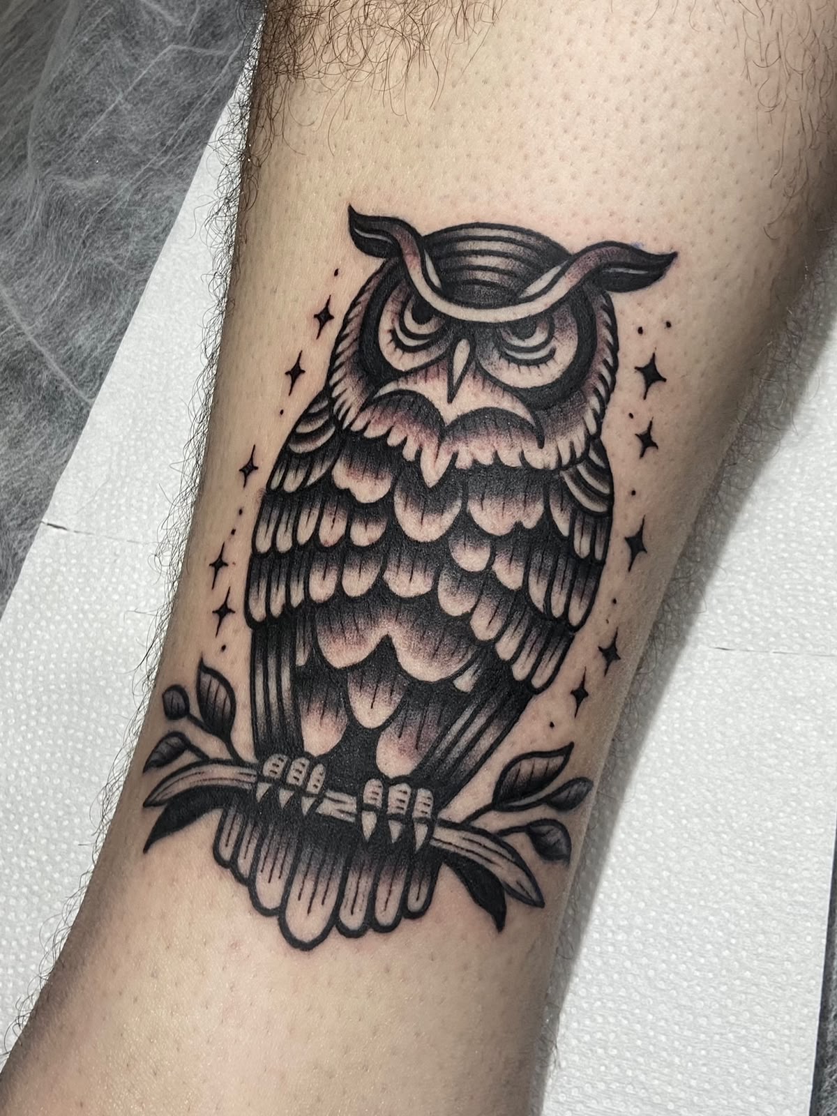 Tatuagem de coruja em preto e cinza na perna